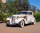 AUT 19 RK0368 03
1935 Auburn Model 851 Phaeton Cream Low 3/4 Front View On Pavement By Trees