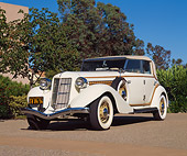 AUT 19 RK0368 06
1935 Auburn Model 851 Phaeton Cream Low 3/4 Front View On Pavement By Trees