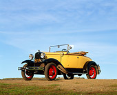 AUT 19 RK0389 01
1931 Ford Model A Deluxe Roadster Yellow Low 3/4 Front View On Dirt Hill Blue Sky