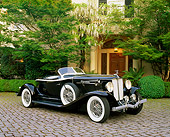 AUT 19 RK0505 03
1933 Auburn V12 Boat-Tail Speedster Black 3/4 Side View On Pavement By Trees And Bushes