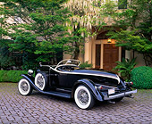 AUT 19 RK0507 03
1933 Auburn V-12 Boat-tail Speedster Black 3/4 Rear View On Pavement By Trees And Bushes