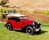 AUT 19 RK0597 03
1937 Morris Eight Touring Convertible Burgundy And Black 3/4 Side View On Grass By Water