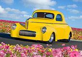 AUT 20 BK0002 01
1941 Willys Coupe Yellow 3/4 Front View On Pavement By Field Of Flowers