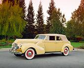 AUT 20 RK0210 01
1940 Buick Phaeton Limited Convertible Yellow 3/4 Side View On Pavement By Trees Filtered