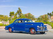 AUT 20 RK0489 01
1941 Cadillac Coupe Blue 3/4 Front View On Pavement By Palm Trees And Houses