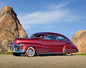 AUT 20 RK0536 01
1948 Chevrolet Fleetline Aerosedan Burgundy 3/4 Side View On Gravel By Tall Rocks