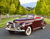 AUT 20 RK0593 01
1941 Buick Roadmaster Phaeton 71C Titan Maroon 3/4 Front View On Pavement By Rows Of Trees