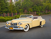 AUT 20 RK0646 01
1947 Lincoln Continental Yellow 3/4 Front View On Pavement By Trees And Wrought Iron Fence