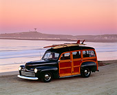AUT 20 RK0013 01
1946 Ford Woody With Surfboards Dark Green 3/4 Side View On Beach At Dusk