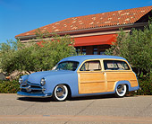 AUT 20 RK0145 01
1949 Ford Woody Blue 3/4 Side View On Pavement By Building