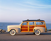 AUT 20 RK0161 01
1946 Ford Super Deluxe Woodie Wagon Tan Side View On Pavement By Water Blue Sky