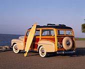 AUT 20 RK0165 01
1946 Ford Super Deluxe Woody Wagon 3/4 Rear View On Pavement With Surfboard By Water