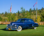 AUT 20 RK0179 01
1947 Cadillac Sedanette Series 62 Blue 3/4 Front View On Grass By American Flags