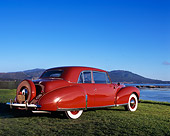 AUT 20 RK0261 02
1941 Lincoln Continental Coupe Red Low 3/4 Rear View On Grass By Water Blue Sky