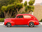 AUT 20 RK0370 01
1940 Ford 2-Door Sedan Red Profile View On Pavement By Building And Trees