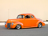 AUT 20 RK0373 01
1940 Ford Deluxe Coupe Orange 3/4 Front View On Pavement By Fence