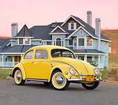 AUT 21 BK0035 01
1957 Volkswagen Beetle Yellow 3/4 Front View On Pavement By House At Dusk