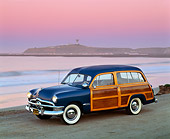 AUT 21 RK0701 04
1950 Ford Woody Blue 3/4 Side View On Sand By Ocean At Dusk