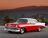 AUT 21 RK0840 04
1956 Chevy Bel Air Red And White 3/4 Side On Pavement Headlights On Mountains In Background At Dusk
