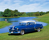 AUT 21 RK0851 05
1953 Pontiac Chieftain Blue Side 3/4 View On Grass Hill By Water And Trees Blue Sky