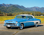 AUT 21 RK0909 03
1955 Desoto 2 Door Hardtop Blue And White 3/4 Front View On Pavement Hills Blue Sky