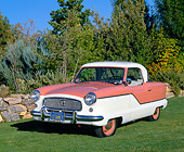 AUT 21 RK1570 03
1956 Nash Metropolitan Peach And White 3/4 Front View On Grass By Trees And Bushes