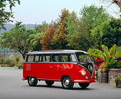 AUT 21 RK1613 02
1953 VW Model 241 Deluxe Microbus Red And Black 3/4 Side View On Pavement By Plants And Trees