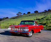AUT 21 RK1622 01
1959 Chevy El Camino Red And Black 3/4 Front View On Pavement By Grass Hill Blue Sky