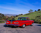 AUT 21 RK1623 01
1959 Chevy El Camino Red And Black 3/4 Rear View On Pavement By Grass Hill Blue Sky