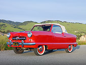 AUT 21 RK2641 01
1955 Nash Metropolitan Convertible Red 3/4 Side View On Pavement By Grassy Hills