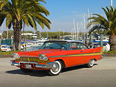 AUT 21 RK2845 01
1957 Plymouth Fury Red And Gold 3/4 Front View On Pavement By Harbor And Palm Trees