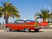 AUT 21 RK2849 01
1957 Plymouth Fury Red And Gold 3/4 Rear View On Pavement By Harbor And Palm Trees