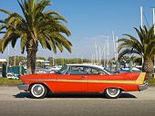 AUT 21 RK2850 01
1957 Plymouth Fury Red And Gold Profile View On Pavement By Harbor And Palm Trees