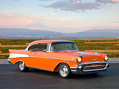 AUT 21 RK2864 01
1957 Chevrolet Bel Air Orange 3/4 Front View On Pavement By Grass Field And Fence