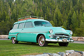 AUT 21 RK2878 01
1954 Dodge Coronet Suburban Sea Green 3/4 Front View On Grass By Stones And Pine Trees