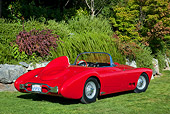 AUT 21 RK2882 01
1958 Moore Roadster Red 3/4 Rear View On Grass By Stones And Shrubs