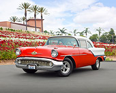 AUT 21 RK3057 01
1957 Oldsmobile 88 Red And White 3/4 Front View On Pavement By Red And White Flowers