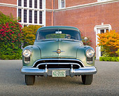 AUT 21 RK3218 01
1950 Oldsmobile Futuramic 88 Club Sedan Moss Green Front View On Pavement By Brick Building