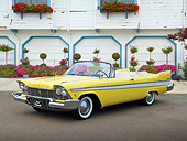 AUT 21 RK3227 01
1957 Plymouth Belvedere Convertible Canary Yellow 3/4 Front View On Pavement By Building And Flowers