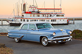 AUT 21 RK3282 01
1955 Lincoln Capri Blue and White 3/4 Side View On Pavement By Boat At Dusk