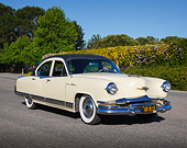 AUT 21 RK3304 01
1953 Kaiser Dragon Cream 3/4 Front View On Pavement By Shrubs