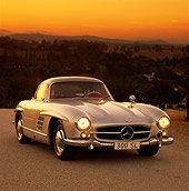 AUT 21 RK0105 04
1956 Mercedes 300SL Gullwing Silver 3/4 Front On Pavement Headlights On Sunset