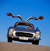 AUT 21 RK0107 03
1956 Mercedes-Benz 300SL Gullwing Silver Doors Open Slanted Head On Blue Sky