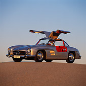 AUT 21 RK0108 03
1956 Mercedes-Benz 300SL Gullwing Silver 3/4 Side On Pavement Doors Open Blue Sky Sunset