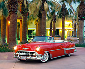AUT 21 RK0126 02
1953 Red Chevy Bel Air Convertible Custom 3/4 Front On Pavement By Palm Trees & Building At Dusk Headlights On