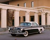 AUT 21 RK0130 08
1955 Black And White De Soto Fireflite 3/4 Front On Pavement By Building Headlights On