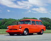 AUT 21 RK0169 02
1955 Orange Studebaker Conestoga Wagon Low 3/4 Side On Pavement By Trees And Hills Blue Sky