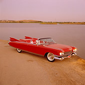 AUT 21 RK0223 05
1959 Cadillac Eldorado Convertible Red Overhead 3/4 Side View On Dirt Headlights On By Lake At Dusk
