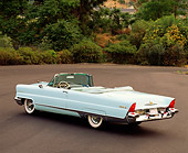 AUT 21 RK0274 02
1956 Lincoln Premier Convertible Light Blue 3/4 Rear View On Pavement By Trees And Bushes