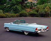 AUT 21 RK0274 04
1956 Lincoln Premier Convertible Light Blue 3/4 Rear View On Pavement By Trees And Bushes